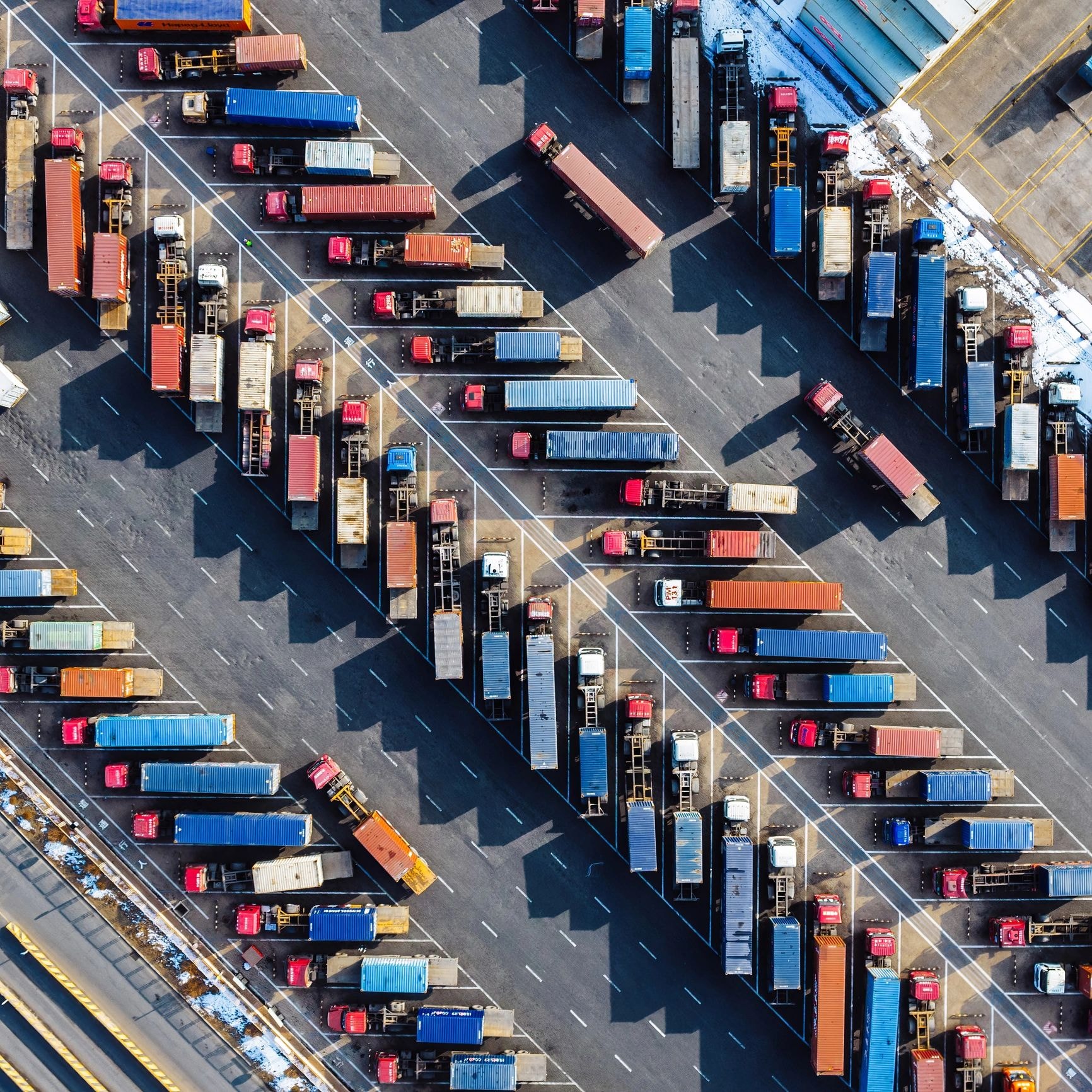 Aerial view of shipping port with containers and trucks